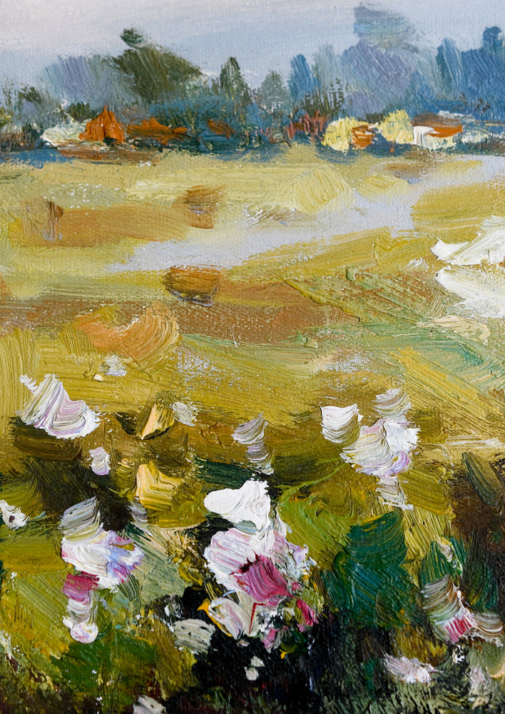 A framed original oil painting of a colorful meadow in the countryside.
