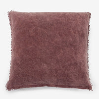 Plum: A velvet throw pillow with pom pom trim in plum color.