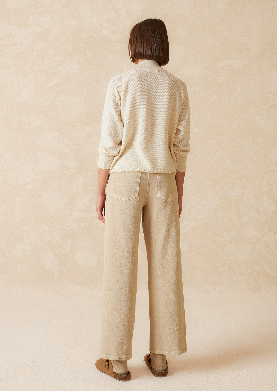 A pair of ecru wide leg jeans with vertical seam down front.