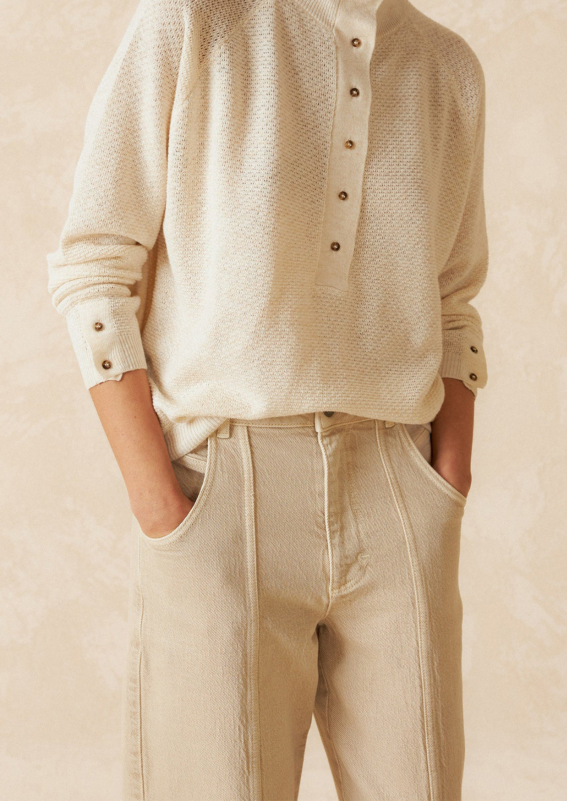 A pair of ecru wide leg jeans with vertical seam down front.