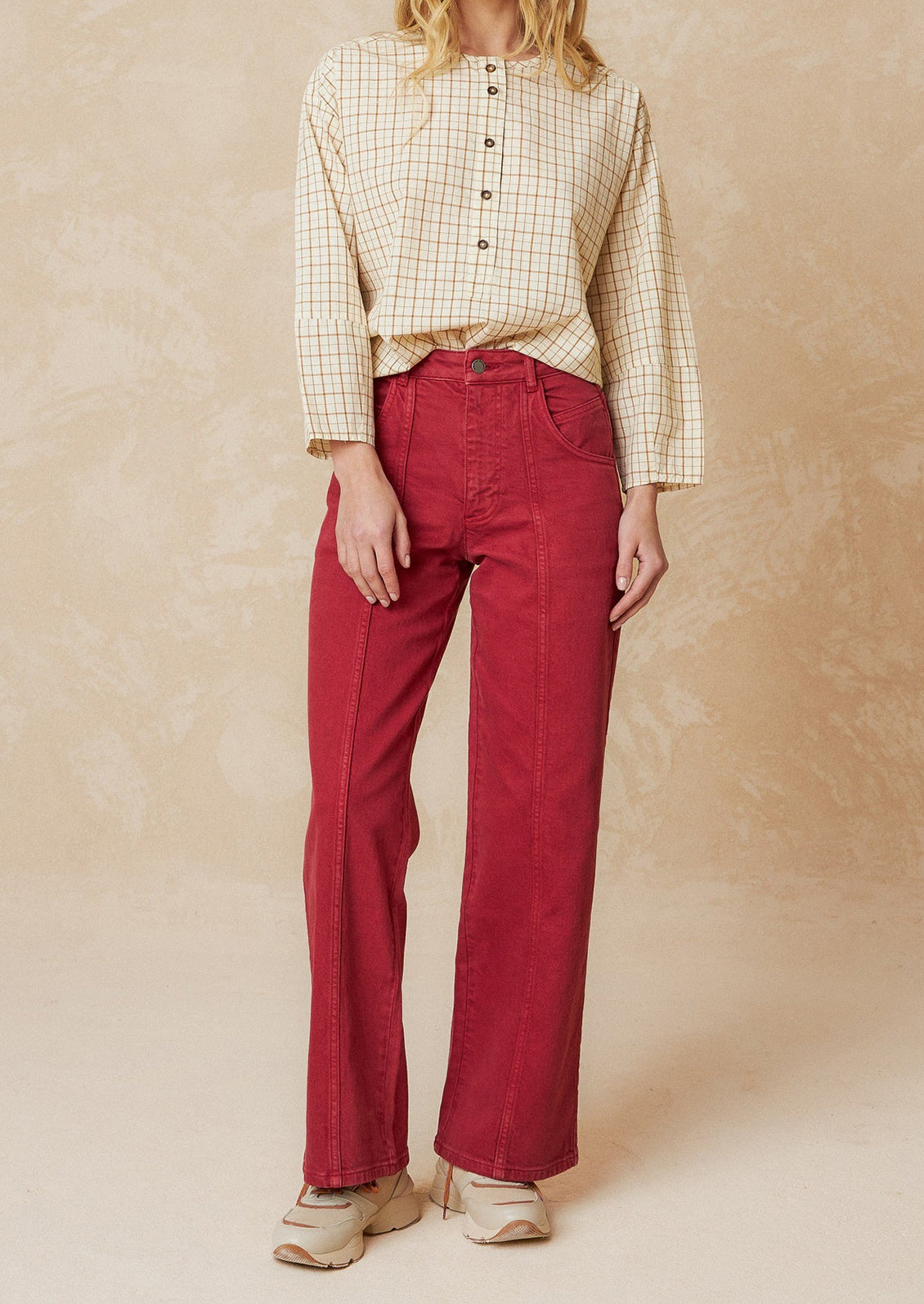 A pair of red wide leg jeans with vertical seam down front.