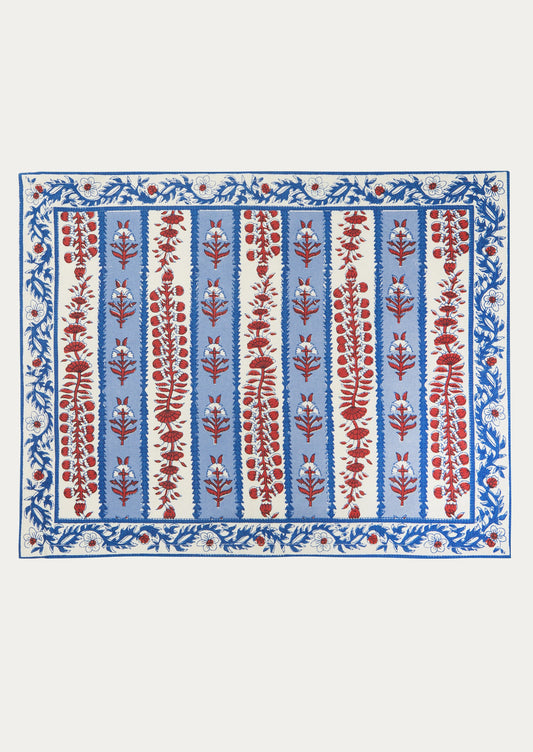 A cotton placemat with block printed floral pattern in red and blue on white background.