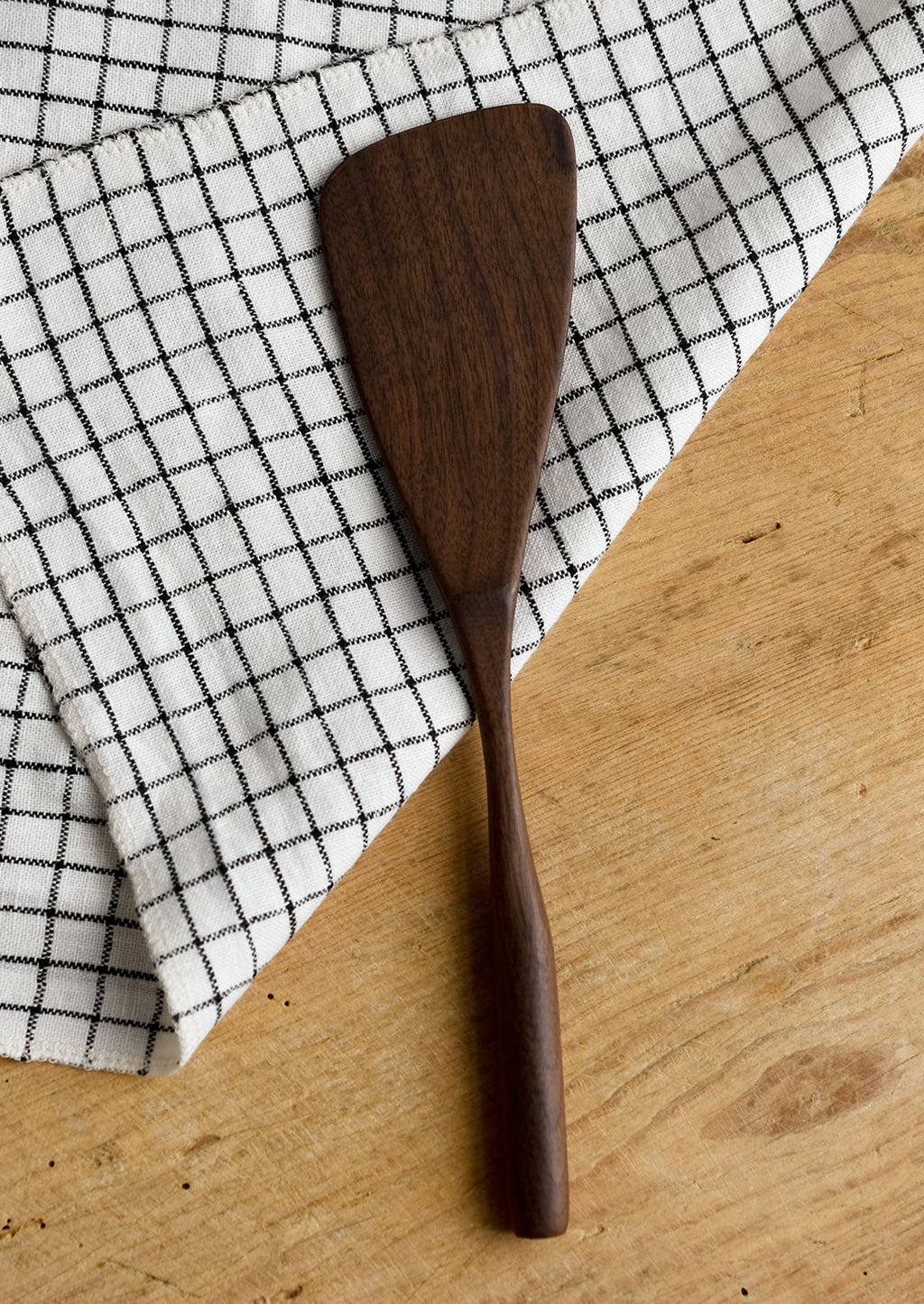 Narrow: A walnut wood spatula in standard shape.