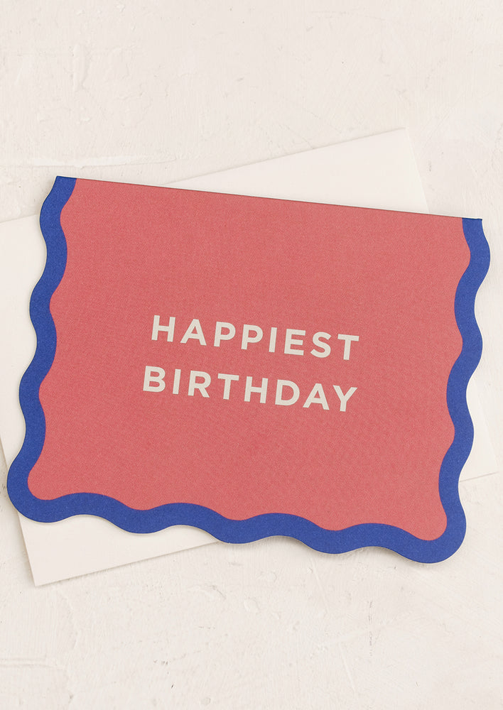 A wavy edge pink and blue card reading "Happiest birthday".