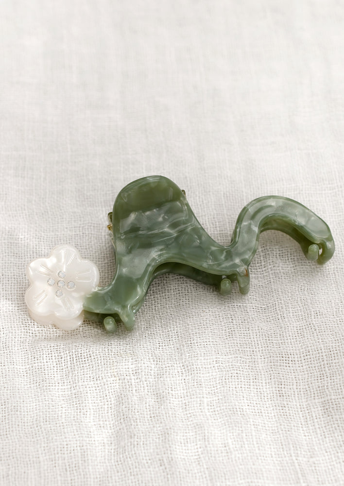 A wavy green hair claw with pearl white flower.