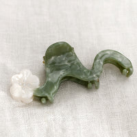 Pearl Multi: A wavy green hair claw with pearl white flower.