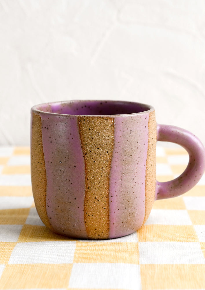 A ceramic mug with wavy stripe pattern in lavender.