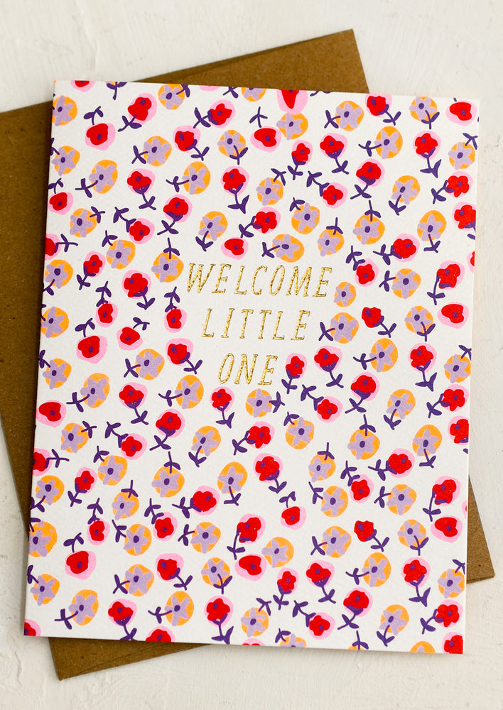 A floral print card reading "Welcome little one".