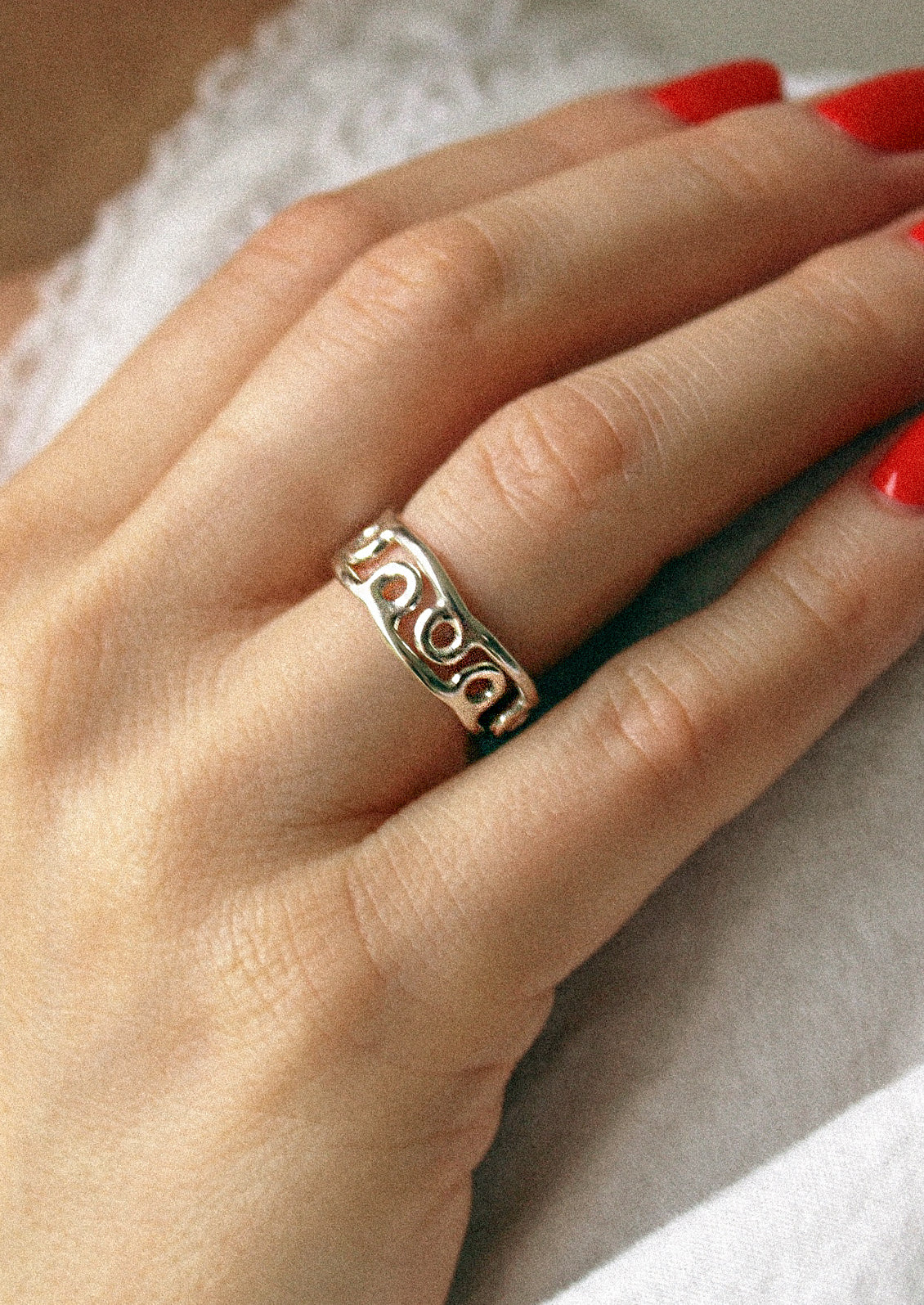 A woman wearing two sterling silver rings with small circles along the band.