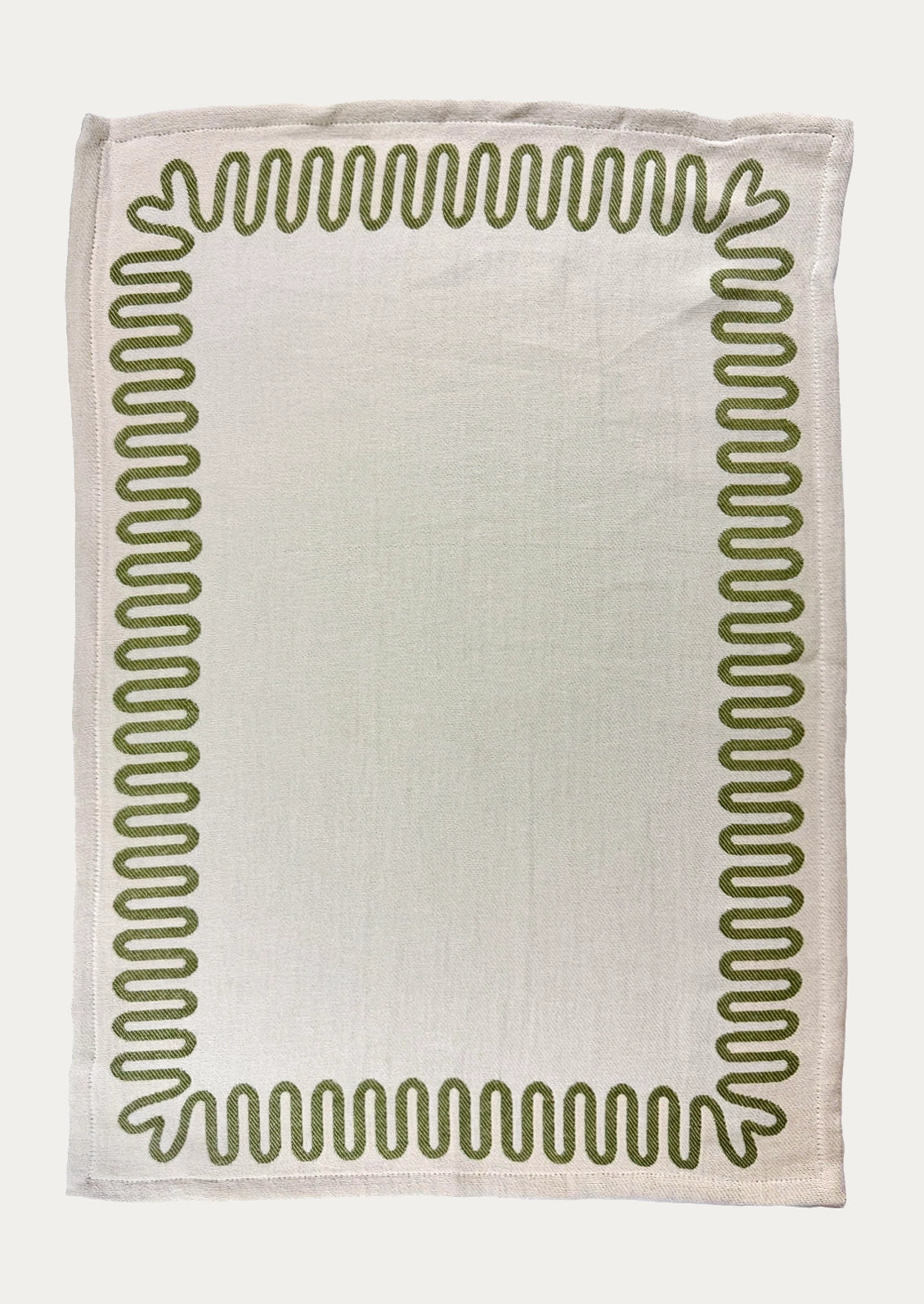 A white dish towel with green squiggle border.