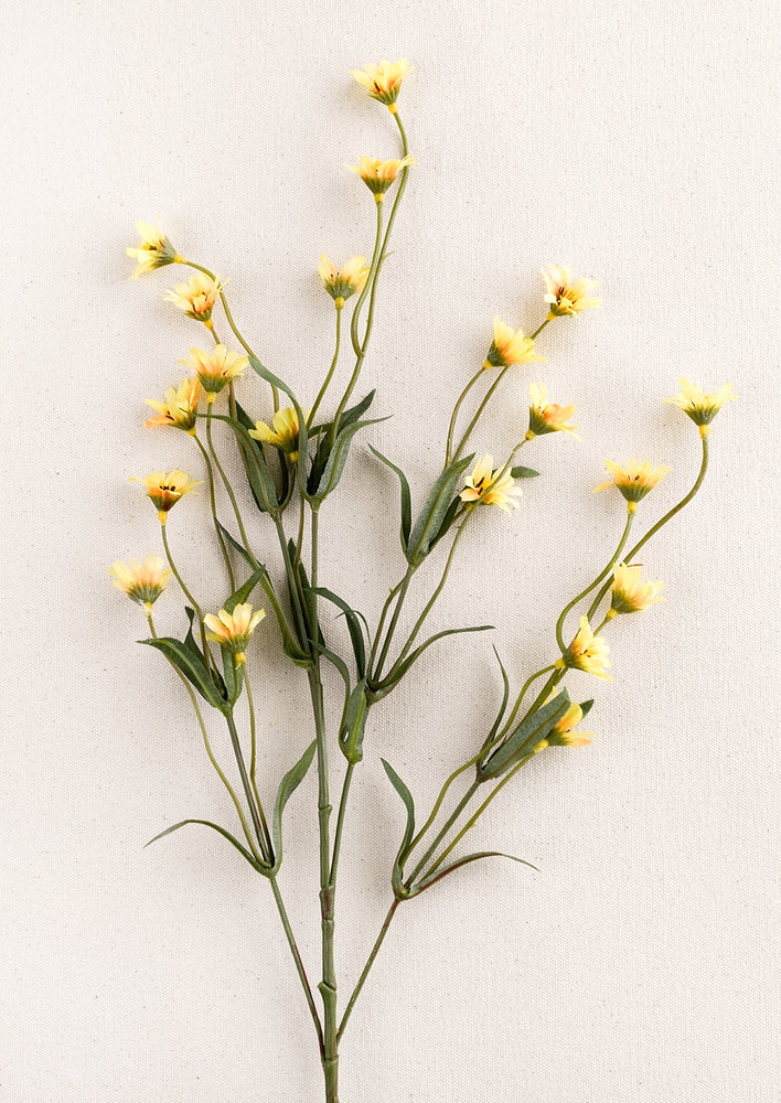 A faux flora spray of yellow wild daisy.