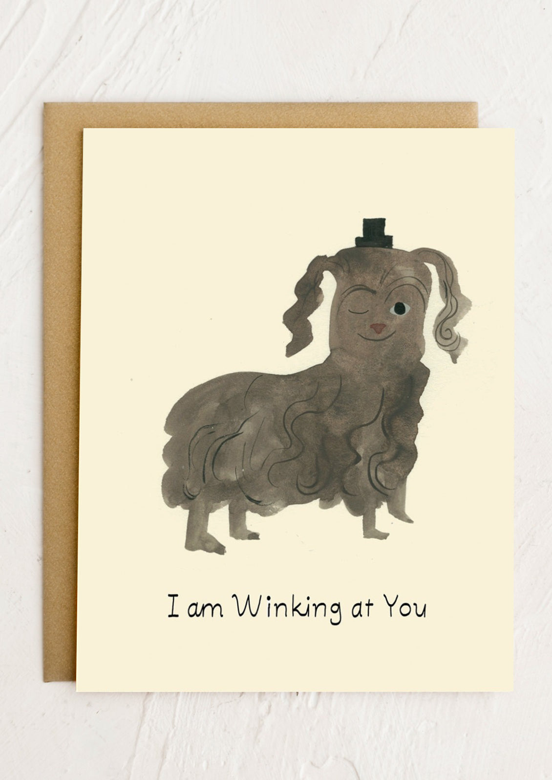 Card with a cartoon dog with pigtails and a bow tie, text 'I am Winking at You', on a beige background.