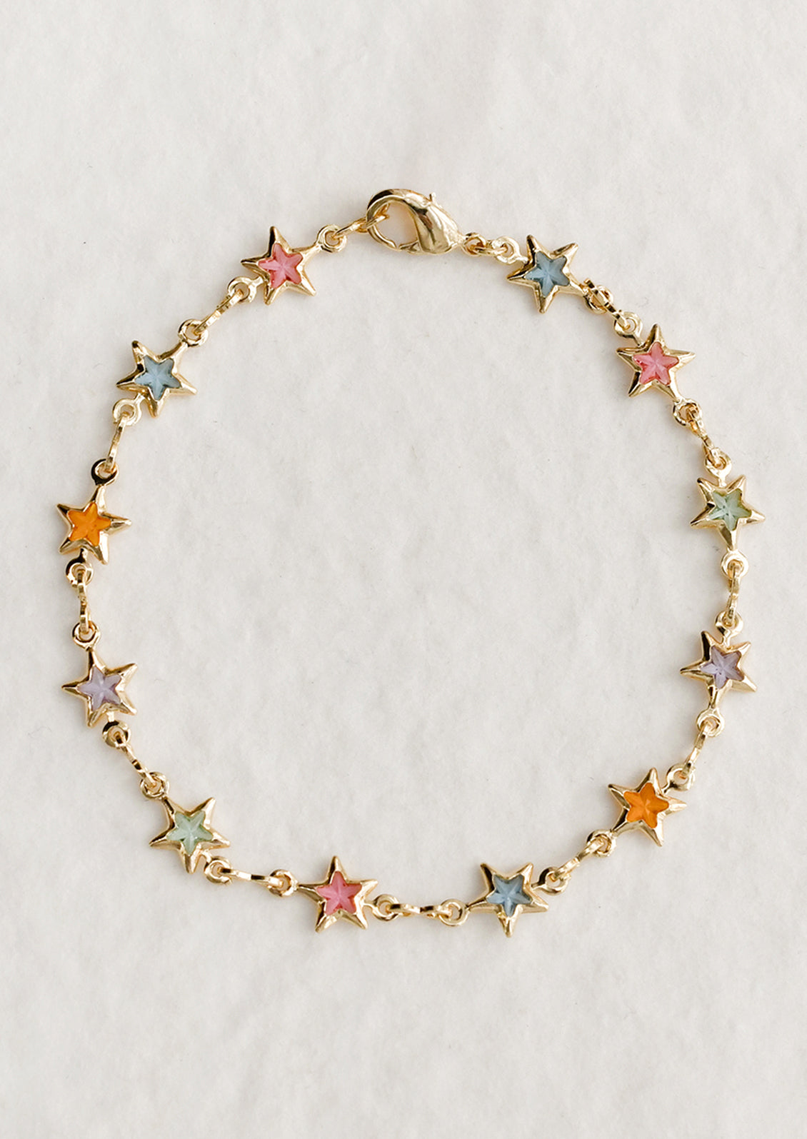 A gold bracelet with pastel colored glass star stations throughout.
