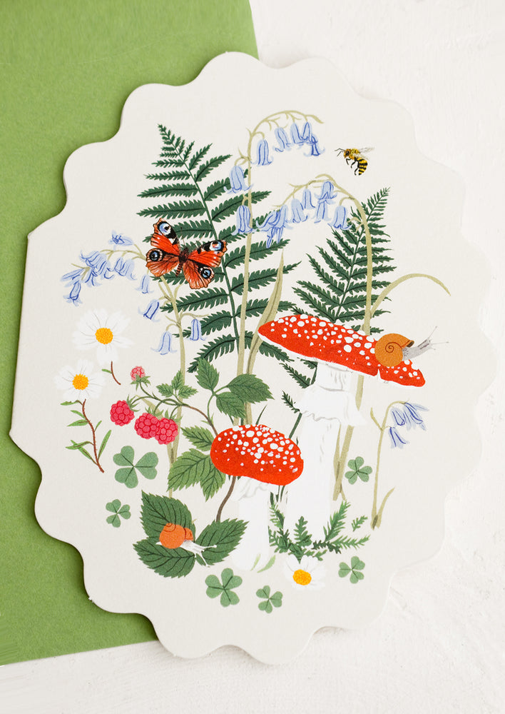 A scalloped oval shaped greeting card with woodland mushroom illustration.