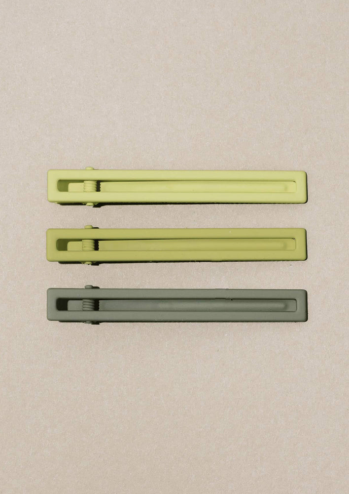 A set of three bar-shaped hair clip sets in shades of green.