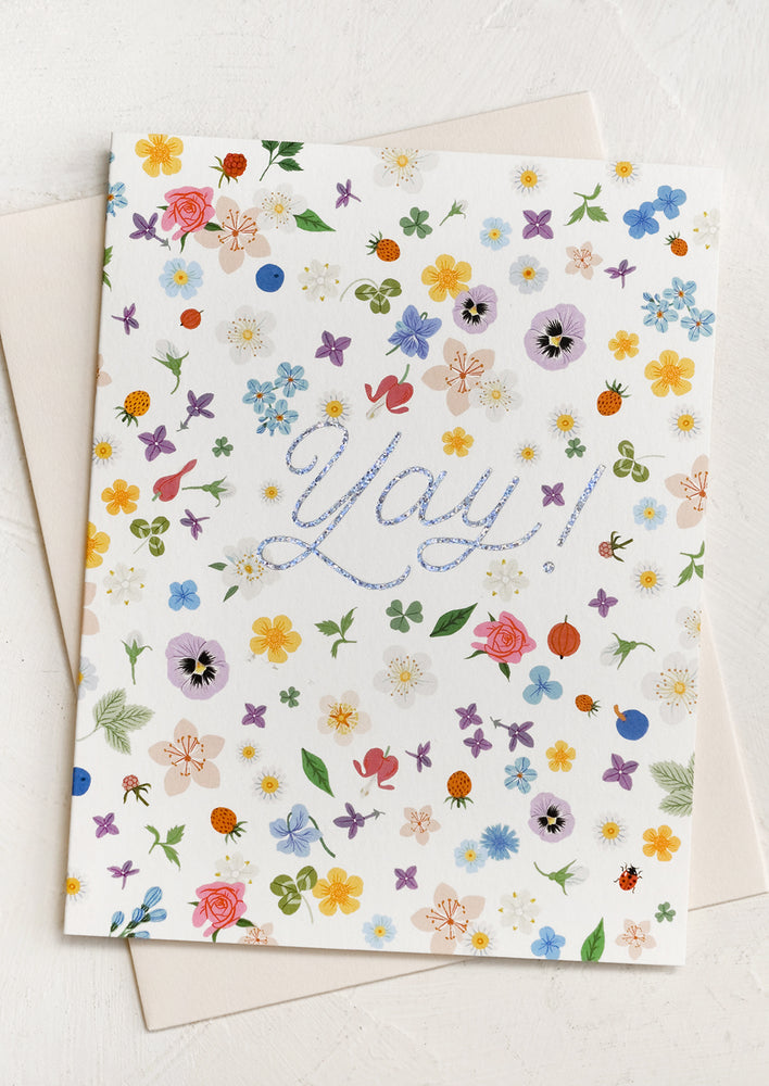 A floral confetti print card reading "YAY!" in silver glitter.