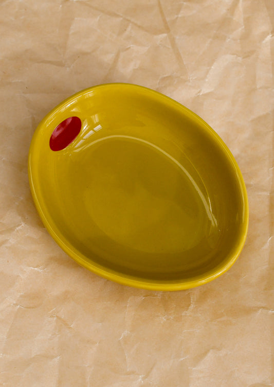 A small ceramic bowl shaped like an olive in yellow.
