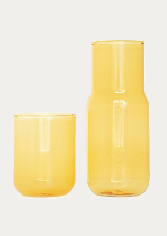 A stackable carafe and cup in transparent yellow color.