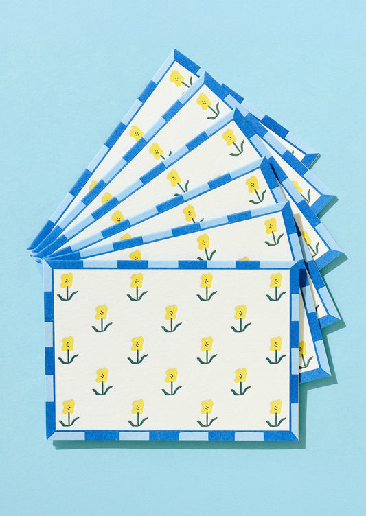 Stack of folded napkins with yellow flower pattern on a blue background