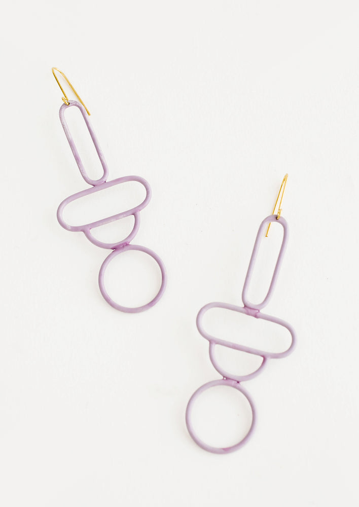 Light purple enamel earrings in the shape of a circle, half circle, horizontal oval, and vertical oval stacked atop each other.