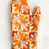 Tomato Multi: A retro floral print quilted oven mitt in red, yellow, orange and pink.