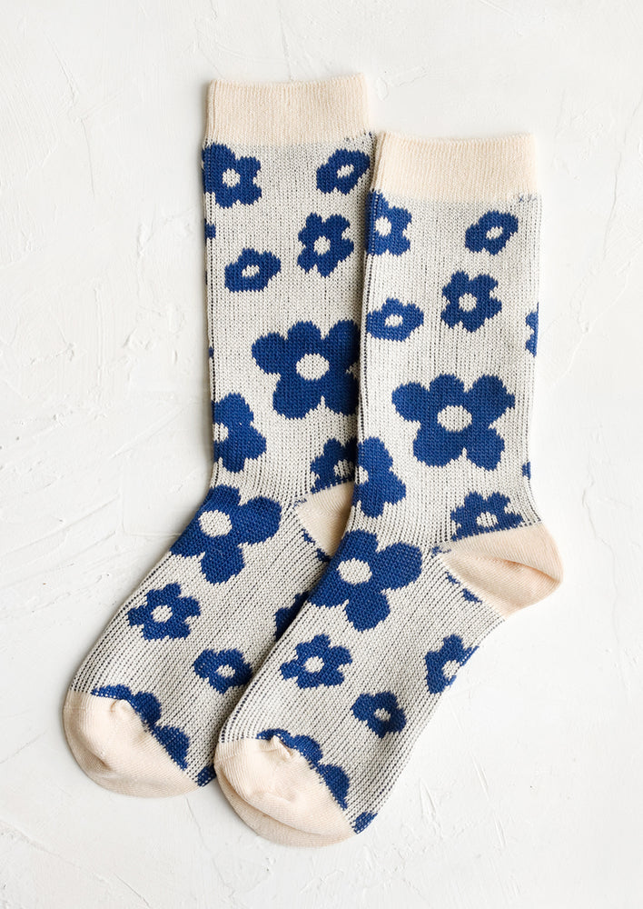 A pair of daisy printed socks in cream and blue.