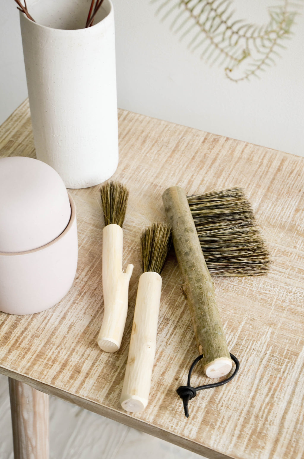 2: Grouping of assorted wooden brushes on a console table