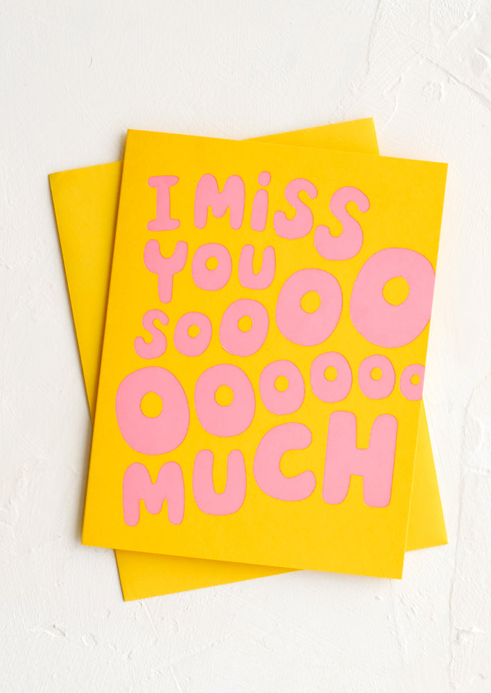 A yellow card with pink letters reading "I Miss You Sooooo Much".