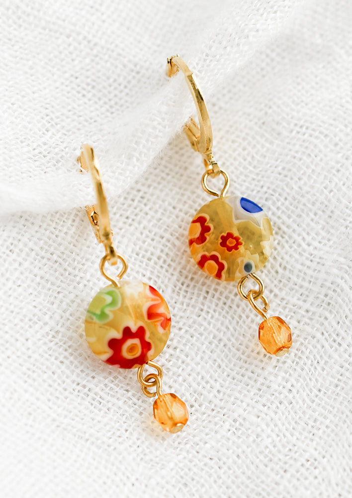 A pair of earrings with floral glass detailing.