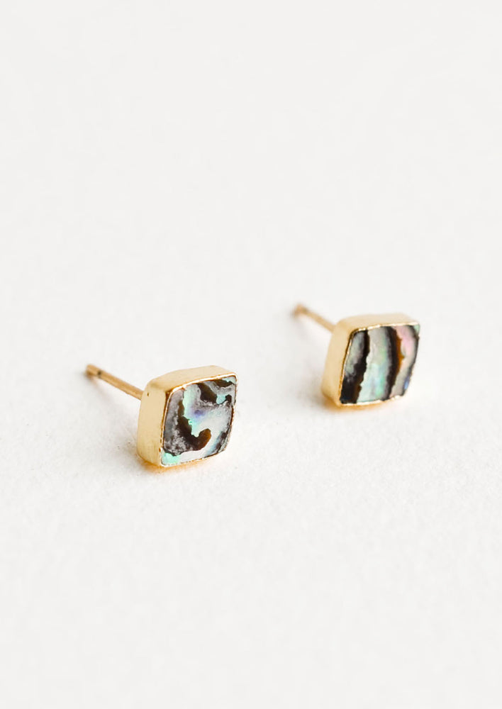 Diamond shape stud earrings with flush set stone. Abalone shell surrounded by gold trim.