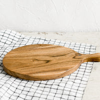 2: An oval shaped paddle-style cutting board in acacia wood.