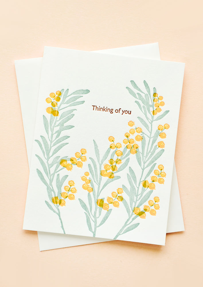 Greeting card with letter press printed acacia flowers and text reading "Thinking of you"
