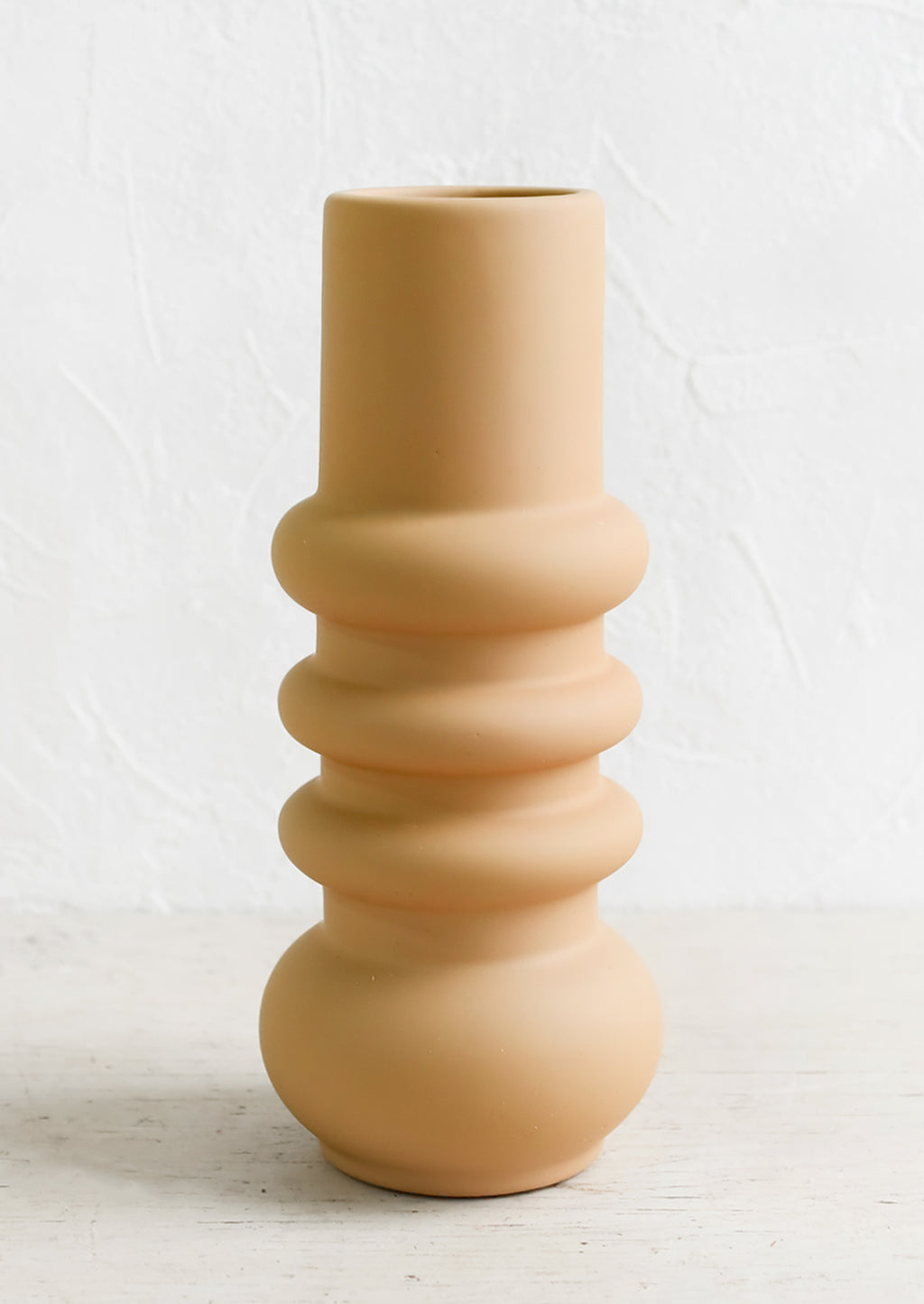 Medium / Tan: A tall matte finish vase in tan with grooved, curvy shape.