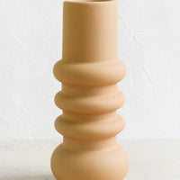 Medium / Tan: A tall matte finish vase in tan with grooved, curvy shape.