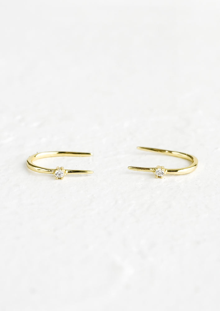 A pair of gold threader studs with single crystal detail.