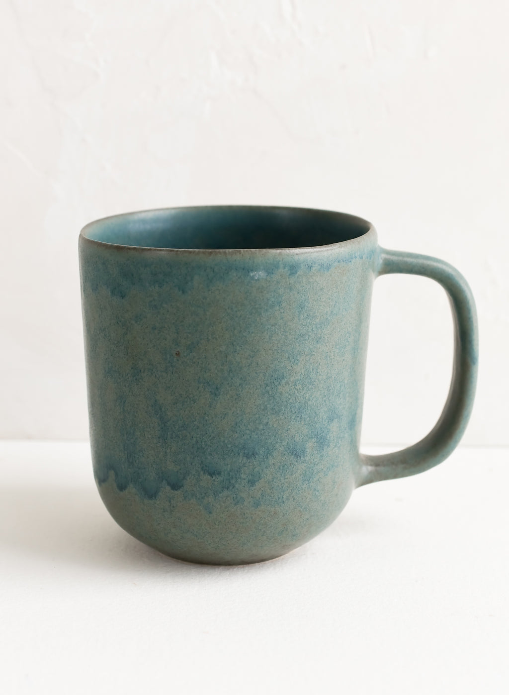 1: A ceramic mug in mottled matte sea blue glaze.