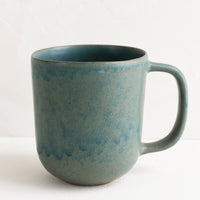1: A ceramic mug in mottled matte sea blue glaze.
