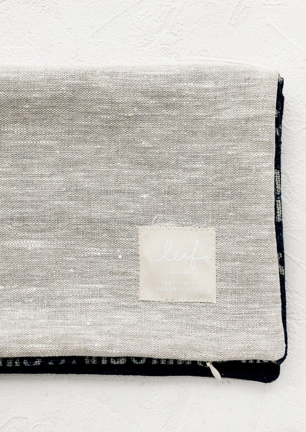 3: Natural linen pillow backing with logo patch.