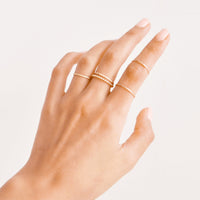 2: Model shot showing hand wearing stacking gold rings.