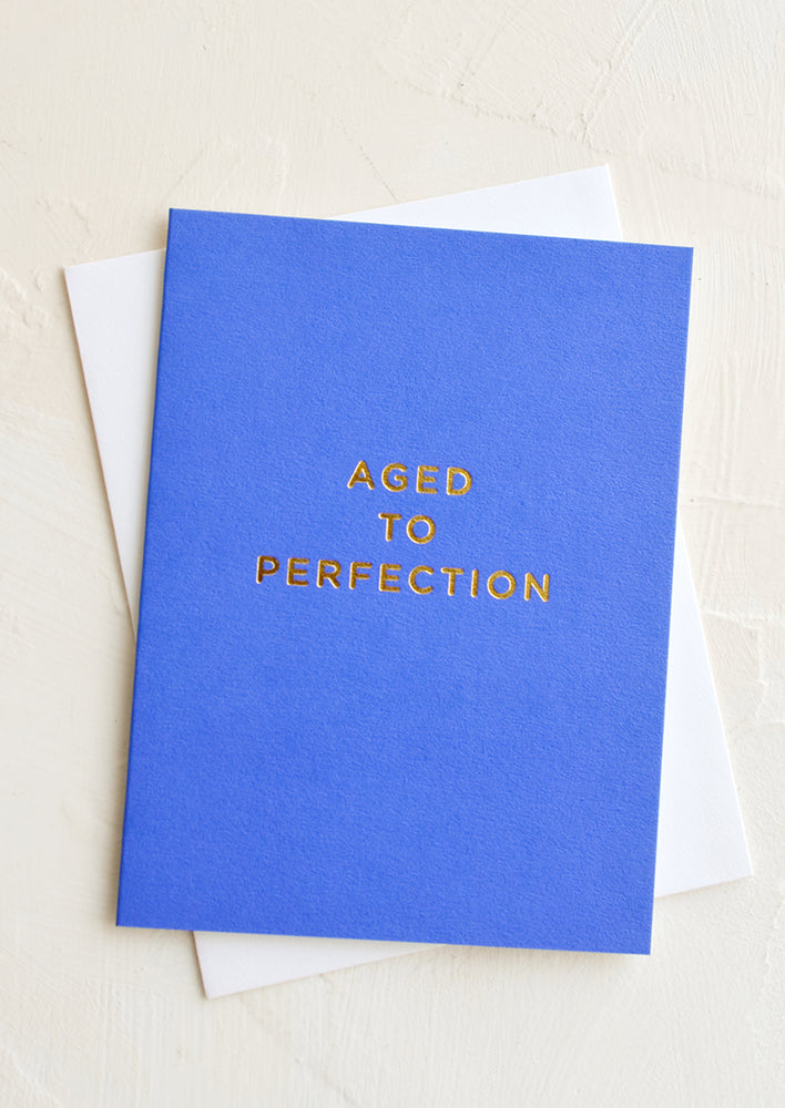 1: A cobalt blue greeting card with golden lettering reading "Aged to perfection".