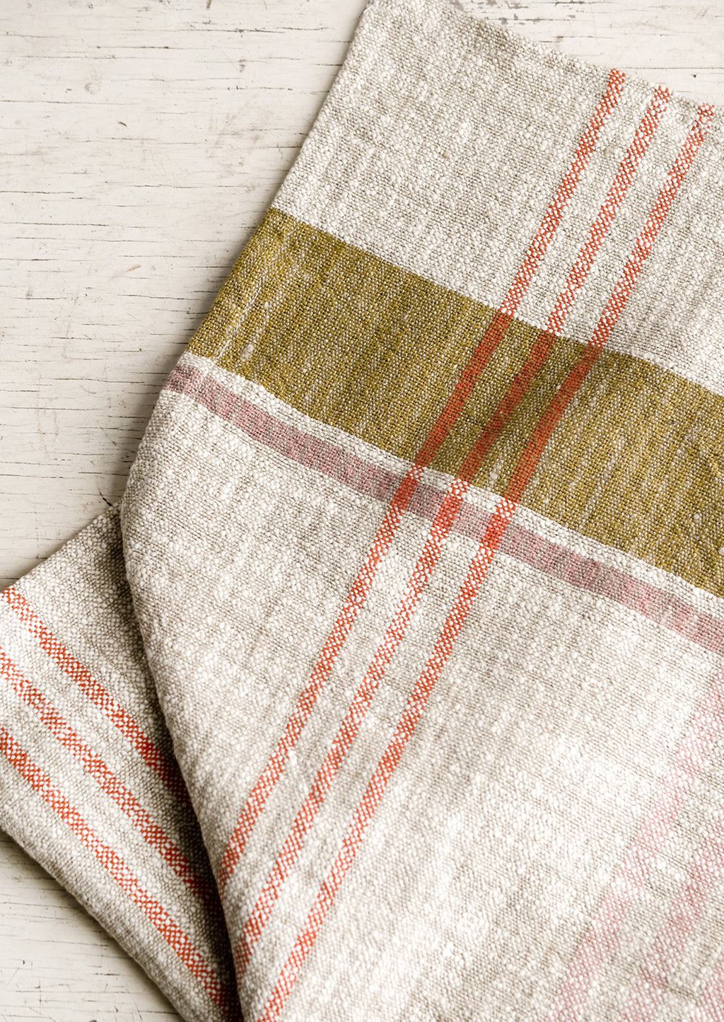 1: A natural tea towel with orange, ochre and pink plaid pattern.