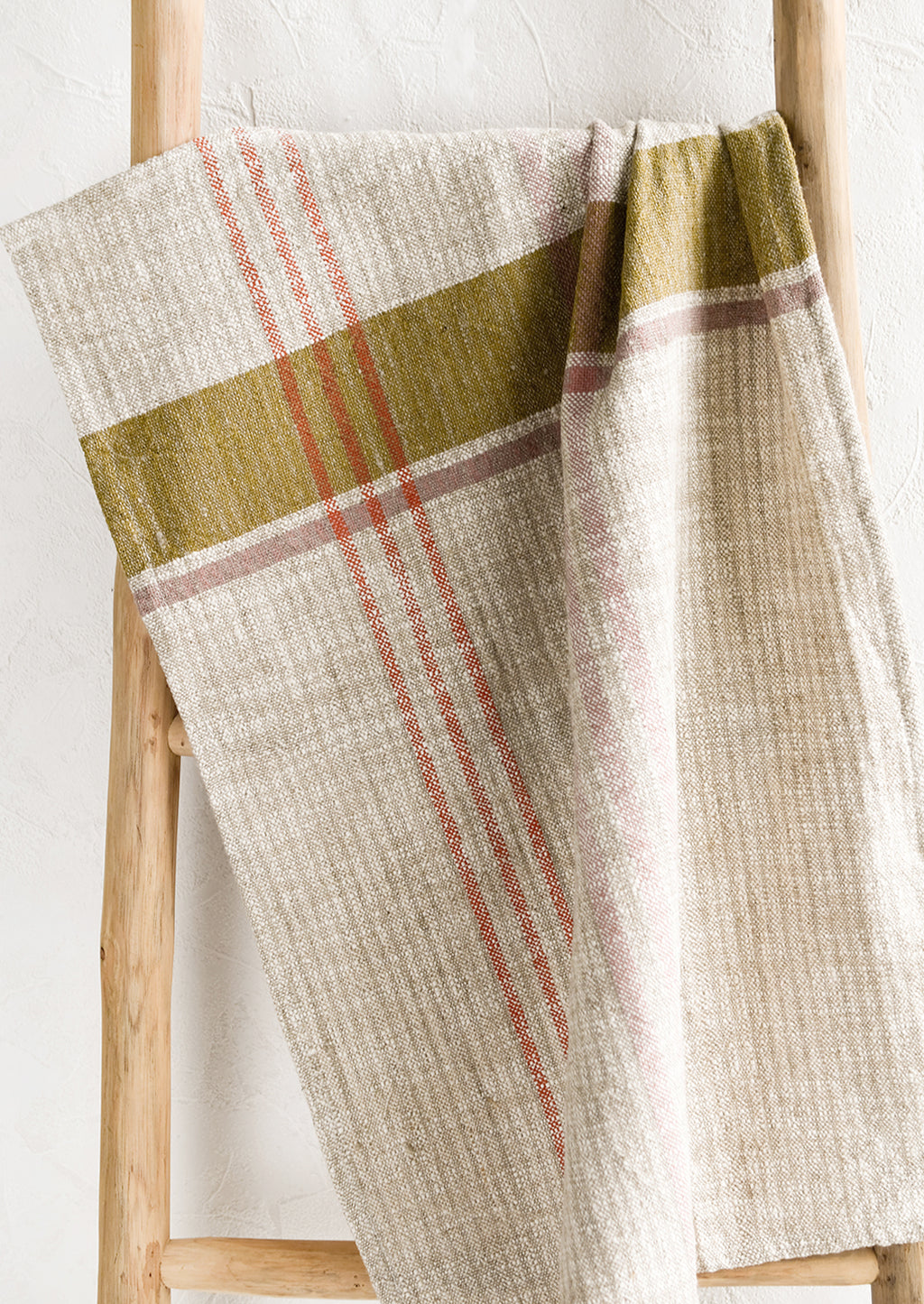 2: A natural tea towel with orange, ochre and pink plaid pattern.