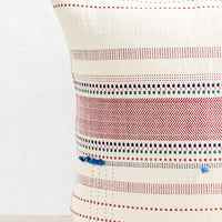 2: A cotton throw pillow with multicolor and red embroidery and tassel detailing.