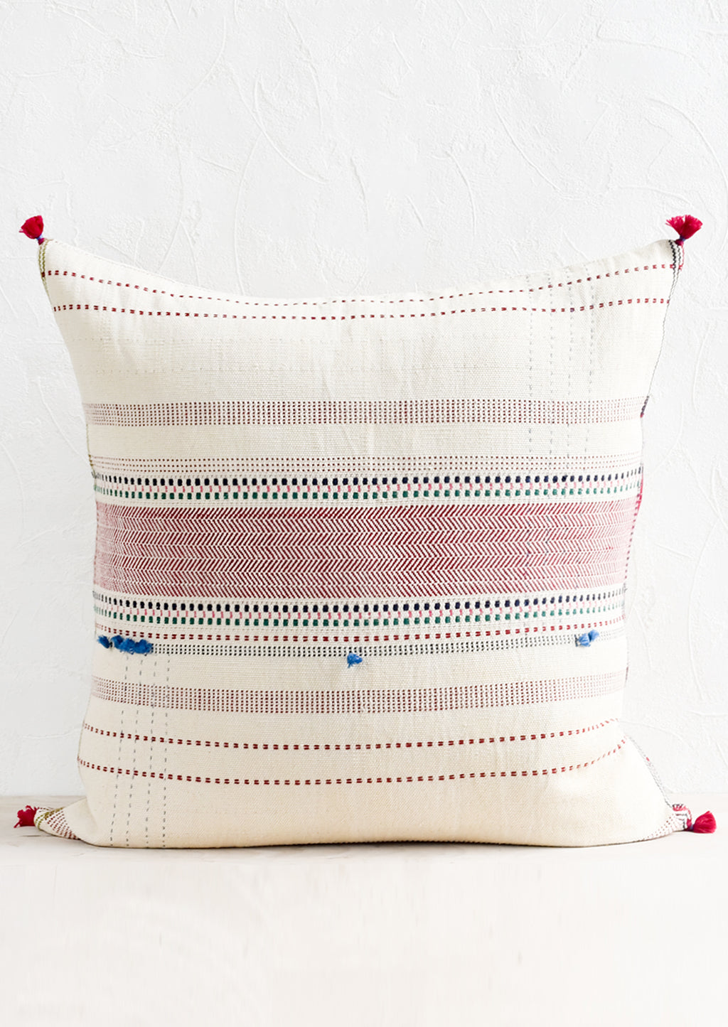 1: A cotton throw pillow with multicolor and red embroidery and tassel detailing.