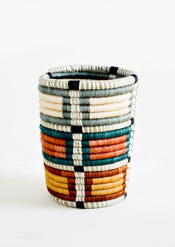 Grey Multi: Pencil cup shaped baskets woven from multicolor sweetgrass. Mix of muted colors in a square geometric pattern.