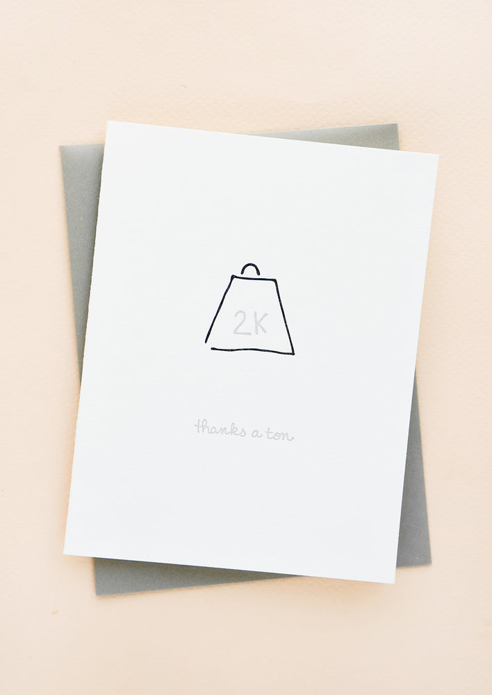 1: Greeting card with letterpress 2k weight and cursive text reads "Thanks a ton", with gray envelope