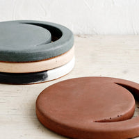 5: An assortment of round concrete trivets with crescent moon shaped cutout.