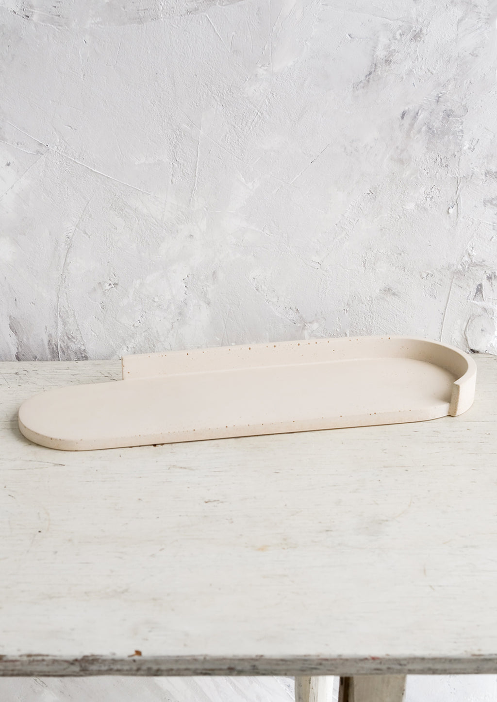 Straw: An elongated oval shaped platter made from straw colored concrete.