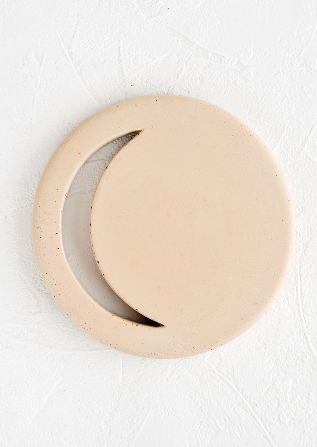 Straw: A round concrete trivet in straw color with crescent moon shaped cutout.