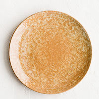 1: A round ceramic plate in dappled, glossy light brown glaze.